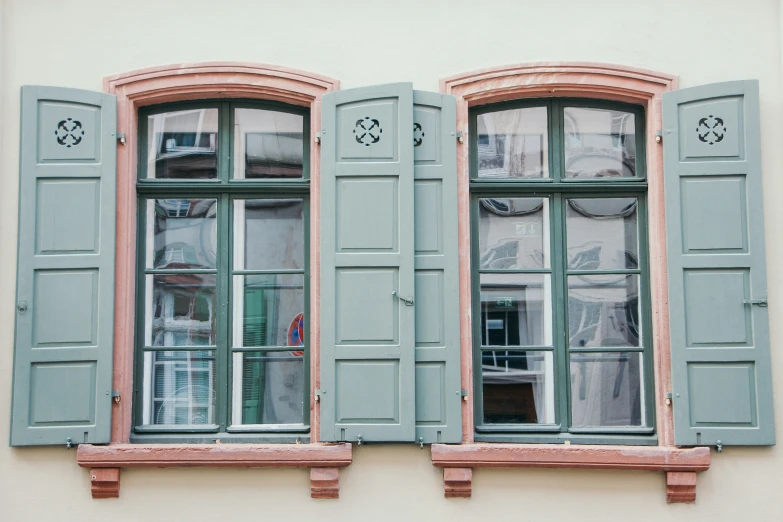 the windows are covered in green shutters