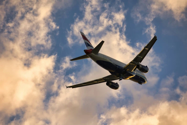 a jetliner flying through the sky with white clouds