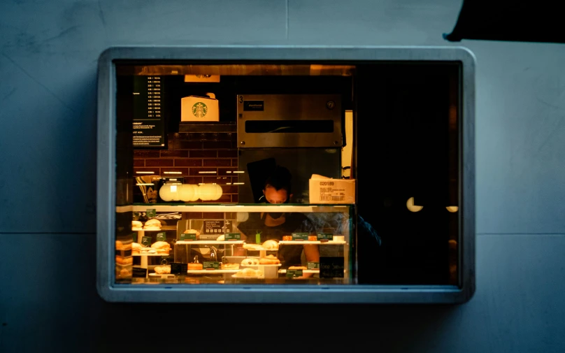 a man working behind a deli display window