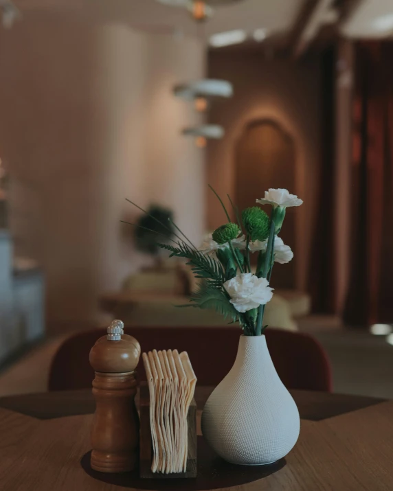 the table with a white vase on top and two books in front