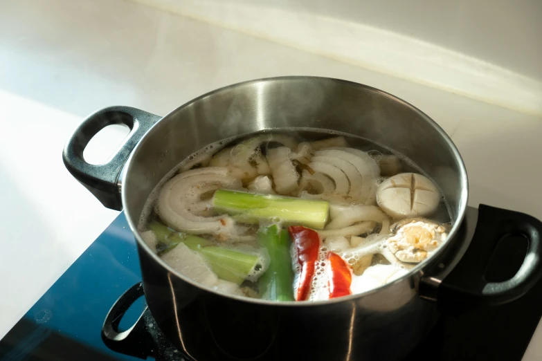 some vegetables are being cooked in a pot on the stove