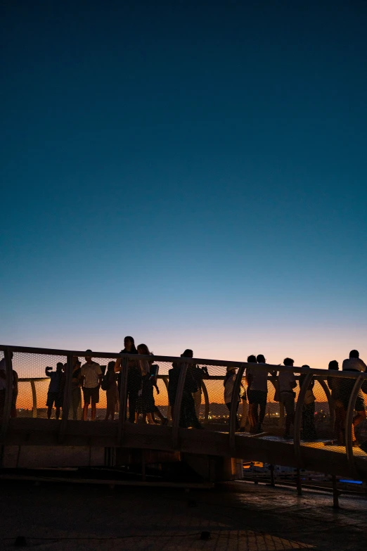 a group of people on a bridge next to a night sky