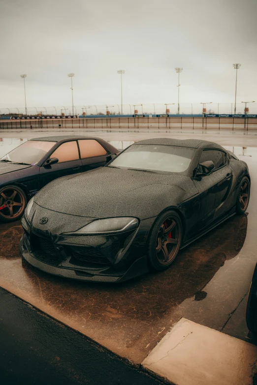 two cars parked next to each other in the rain