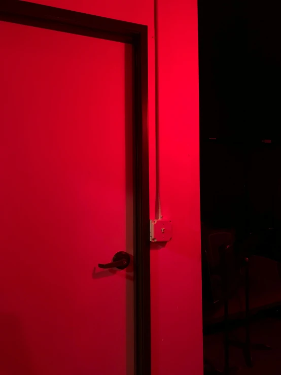a room with a red wall and an open door