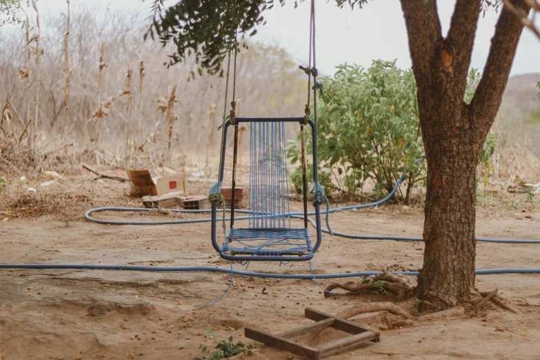 a blue plastic swing on a small wooden post