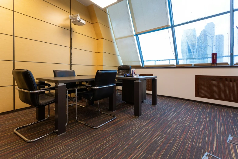 a dining table set up in a long office with city view outside