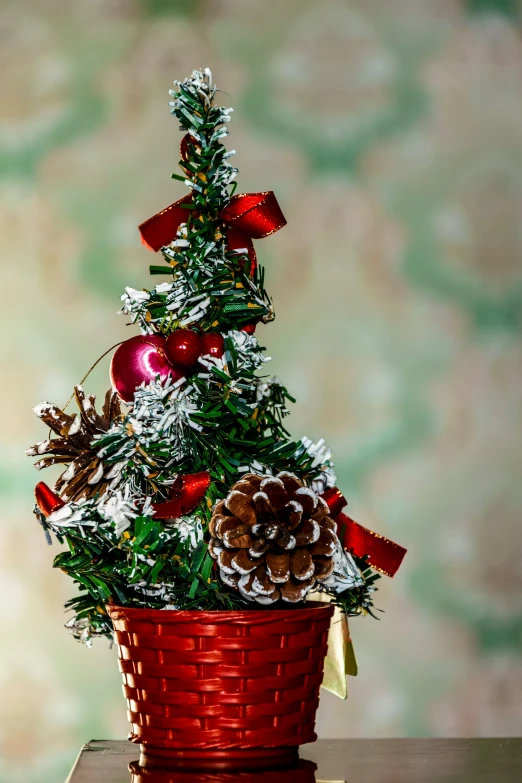 a decorated tree in a basket with red bows and evergreens