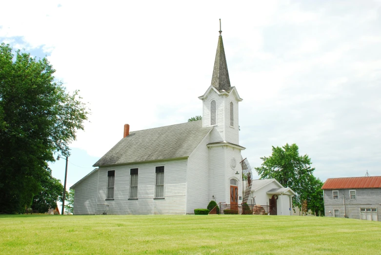 a white church that is standing on the grass