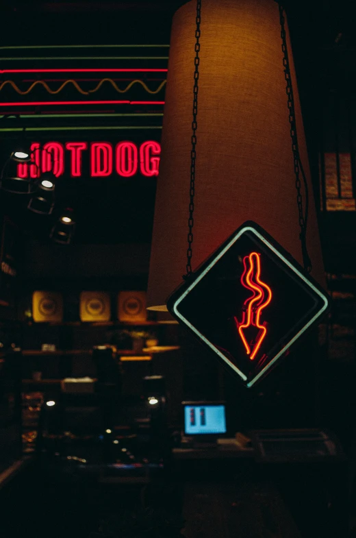 an illuminated dog sign on a dark city street