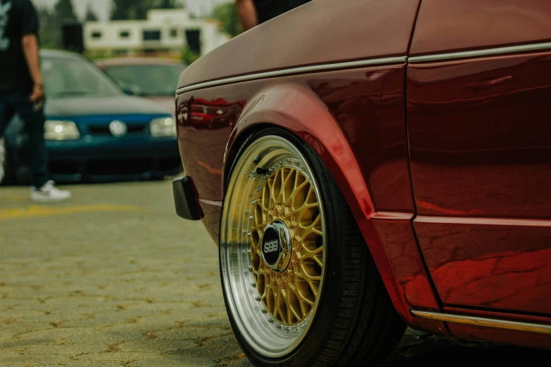 the side of a red vehicle with the yellow wheels