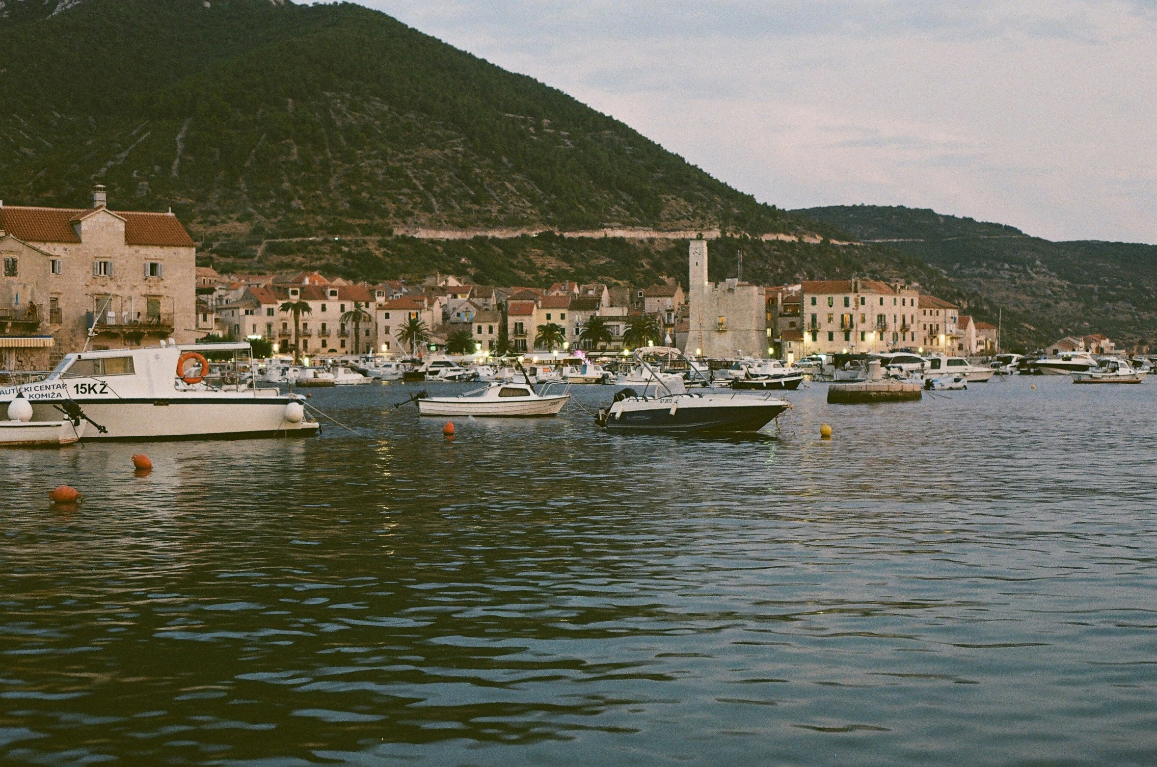 some boats parked in a harbor next to a mountain