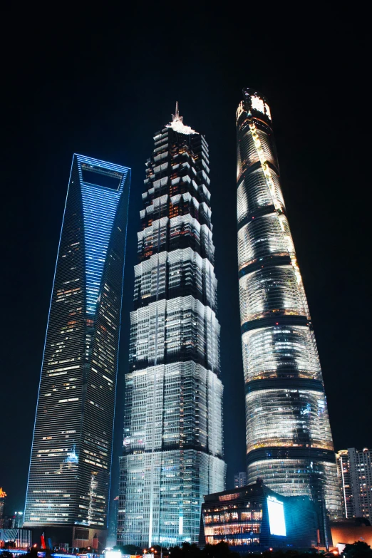 two large glass buildings lit up at night