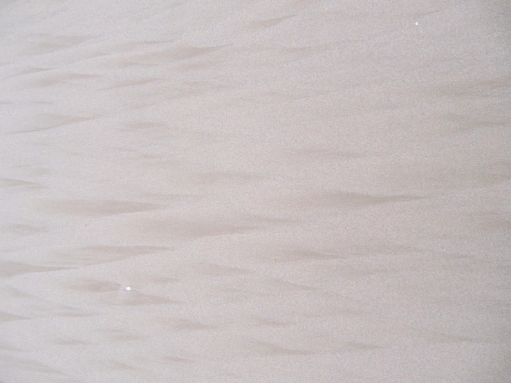 a person walking along the sand of a beach