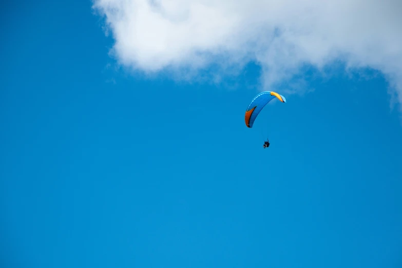 two parachutes are flying through the blue sky