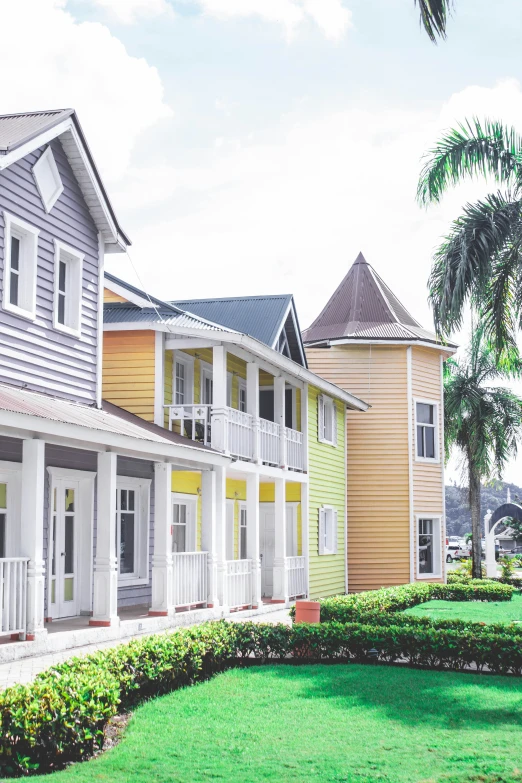 several brightly colored homes on a green lawn