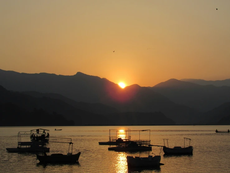 a sunset over a bay in the mountains