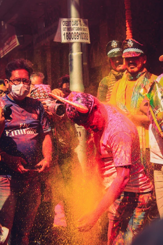 a group of people in colorful colored powder on a street