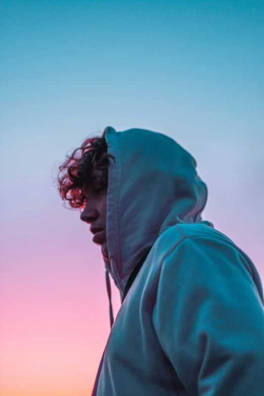 a man with dark hair wearing a hooded sweatshirt