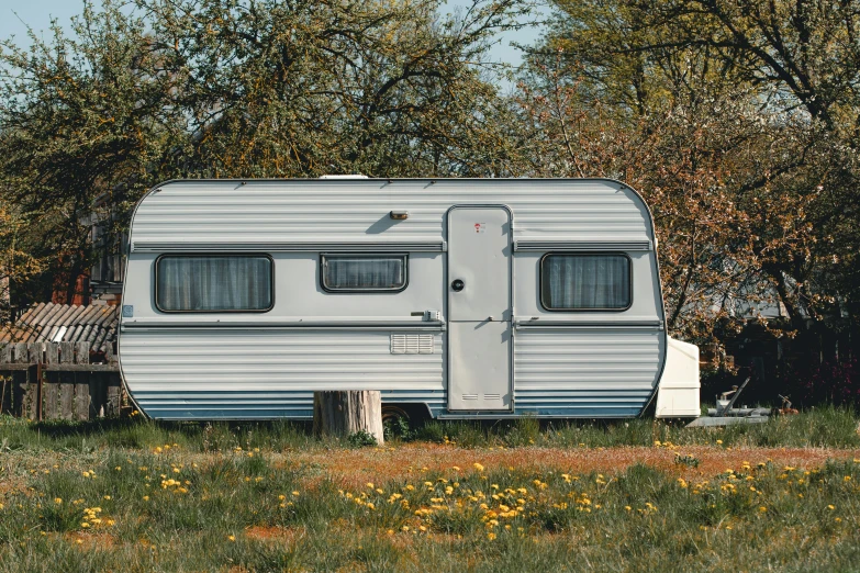 the camper trailer is parked next to some trees