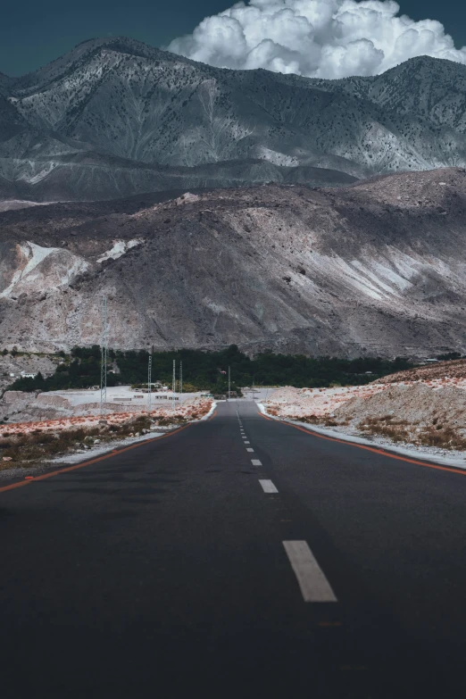 an empty road with mountains in the background