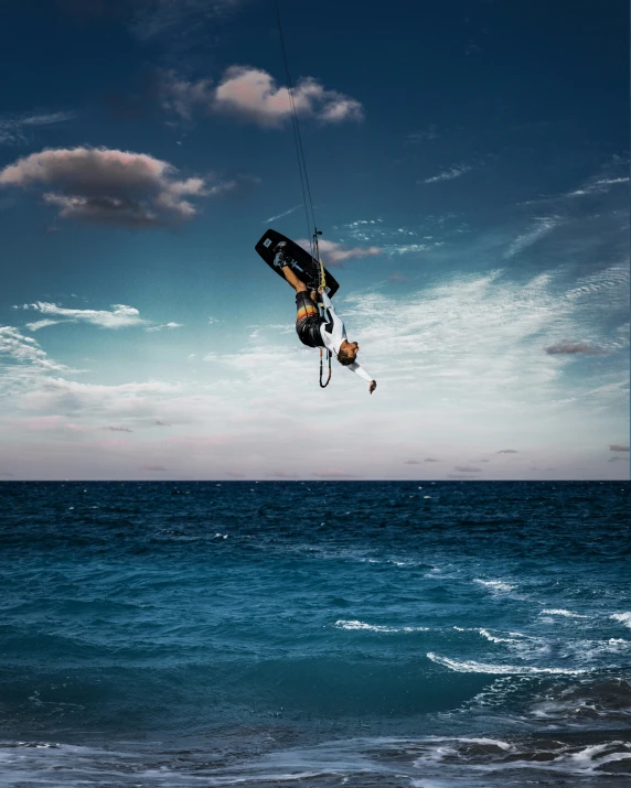 a man suspended from a kite over a body of water