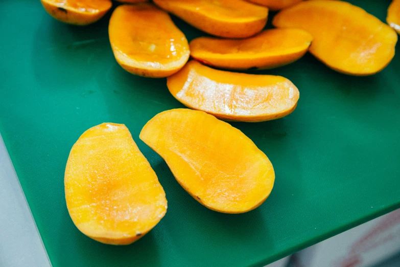 the sliced oranges are on a green board