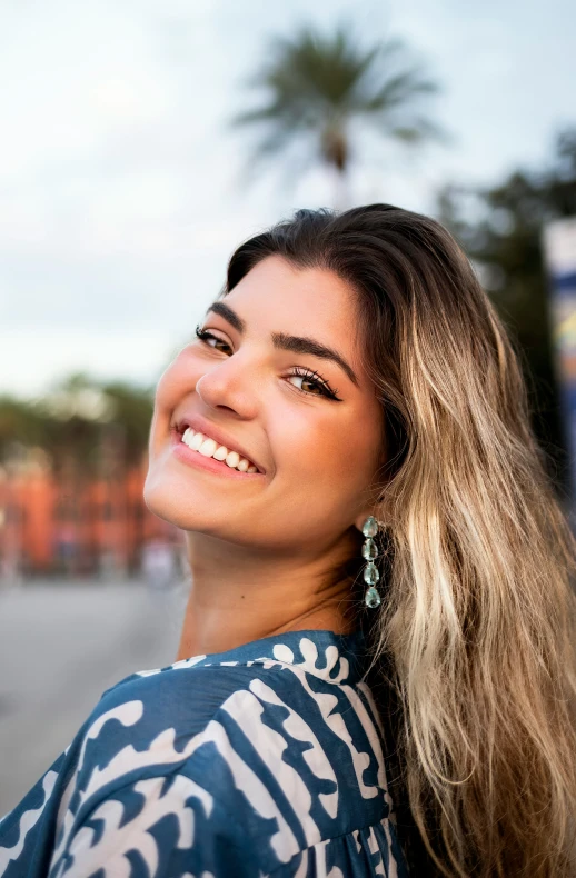 smiling woman wearing earrings and looking up