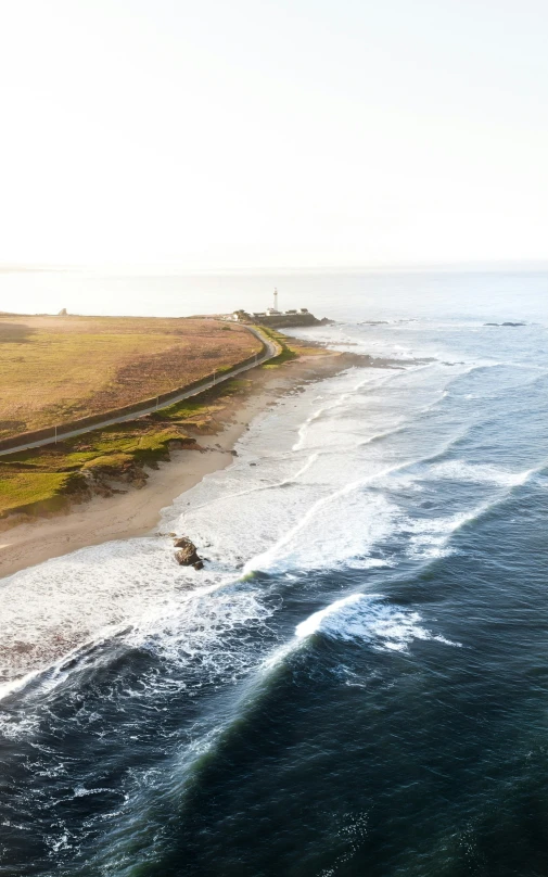 an ocean shore line on the coast with grass and a boat