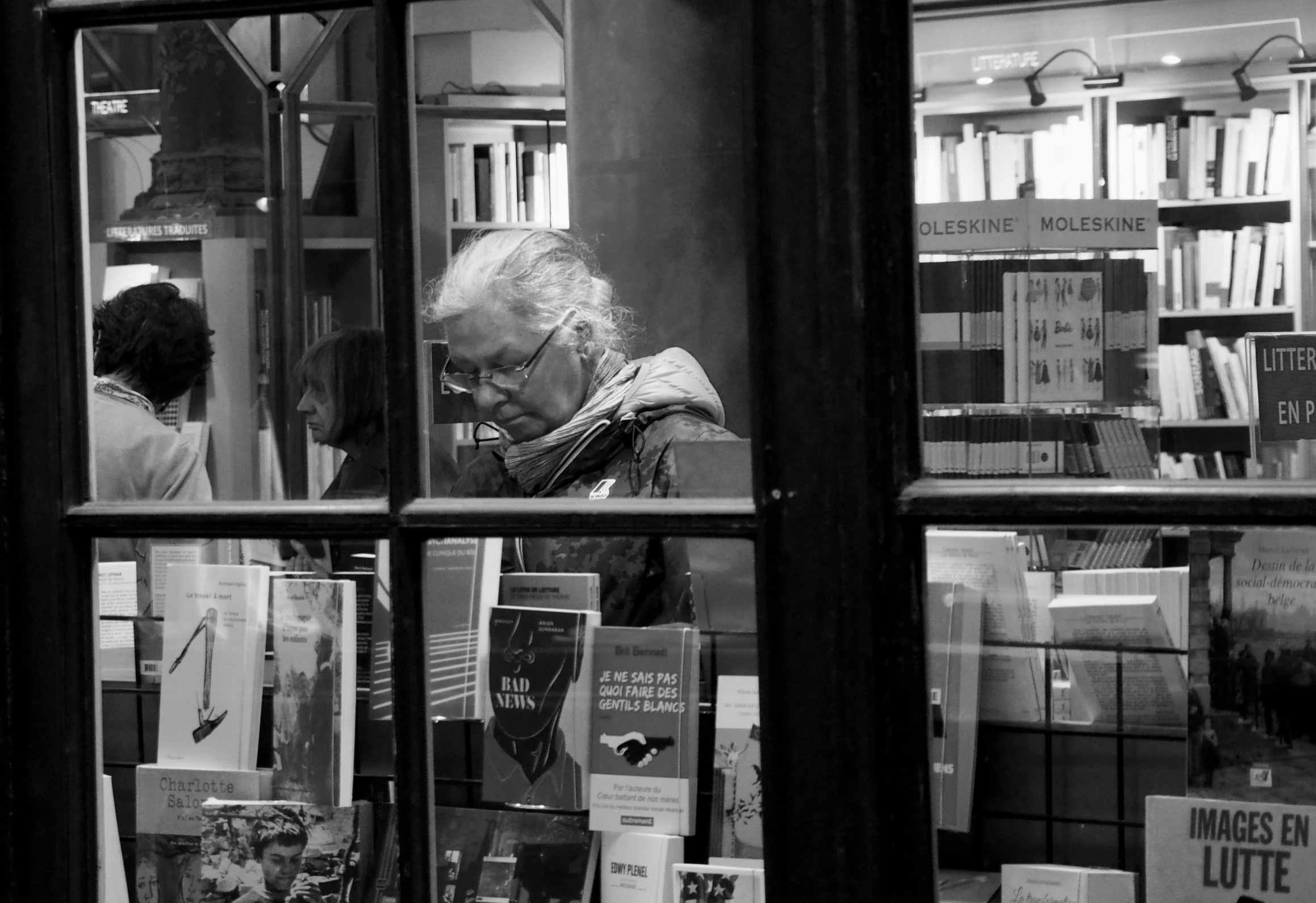 a man reading in a liry looking at books