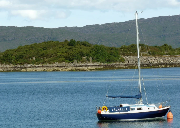 a sail boat is anchored in the middle of the lake