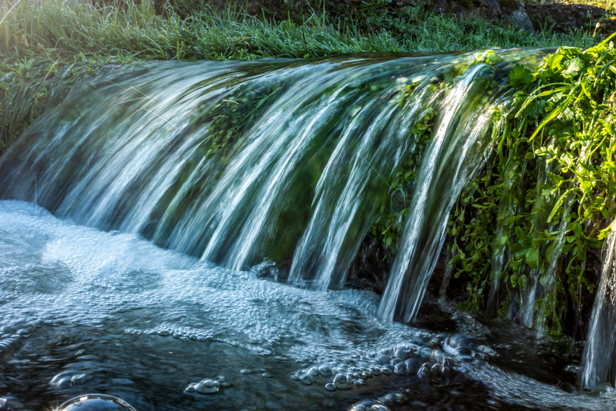 a large waterfall pouring water onto a body of water