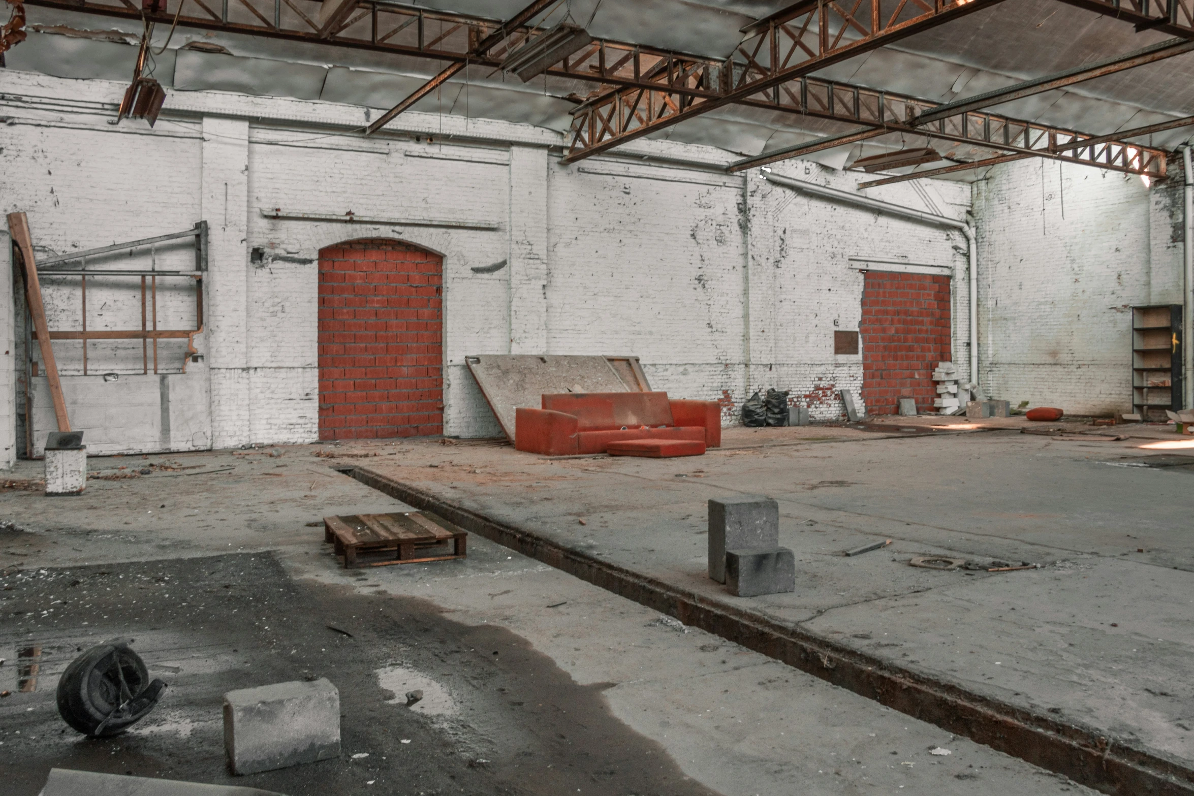 the inside of a warehouse with rust and empty furniture