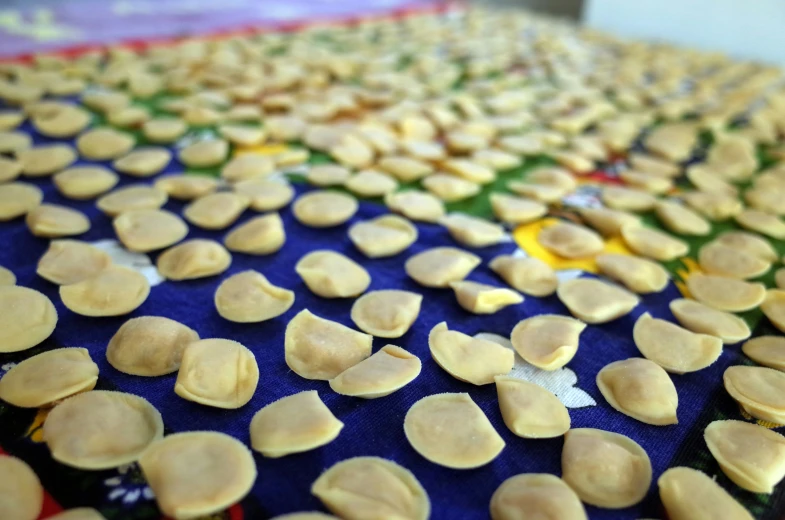 a blue table topped with lots of cupcakes covered in frosting