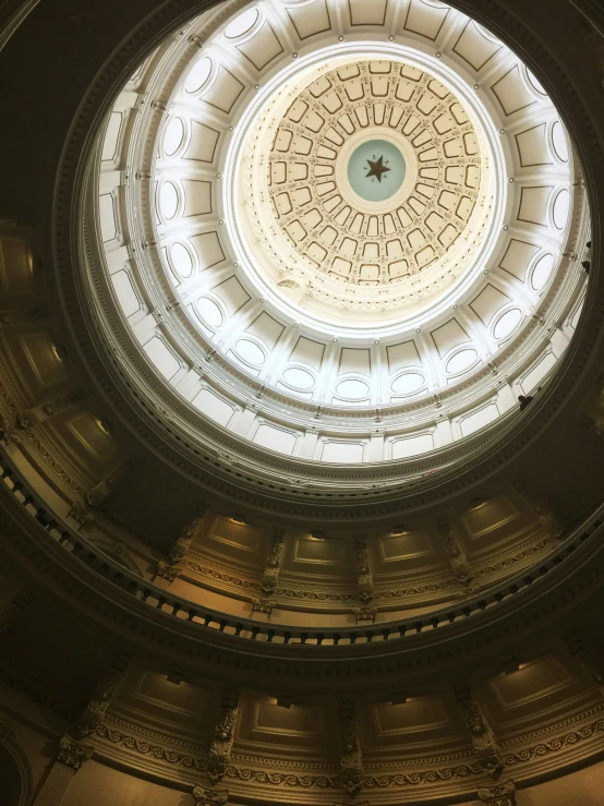 a circular ceiling with the light streaming from it