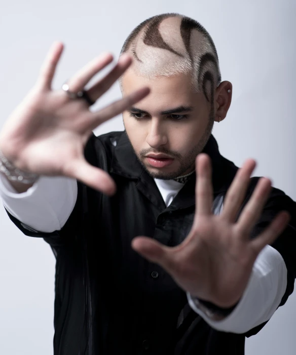 a person with bald hair in his hands with rings on their fingers