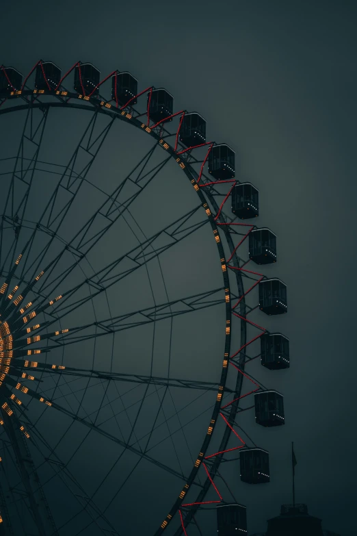 a ferris wheel in the dark on a cloudy day