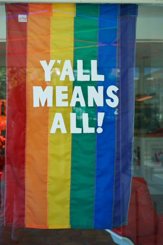 a window display featuring a rainbow colored banner