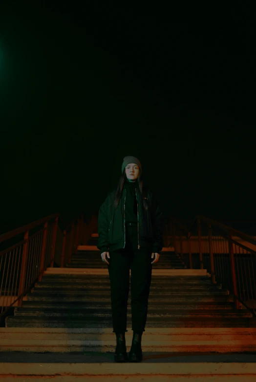 a person in dark clothes stands next to some stairs