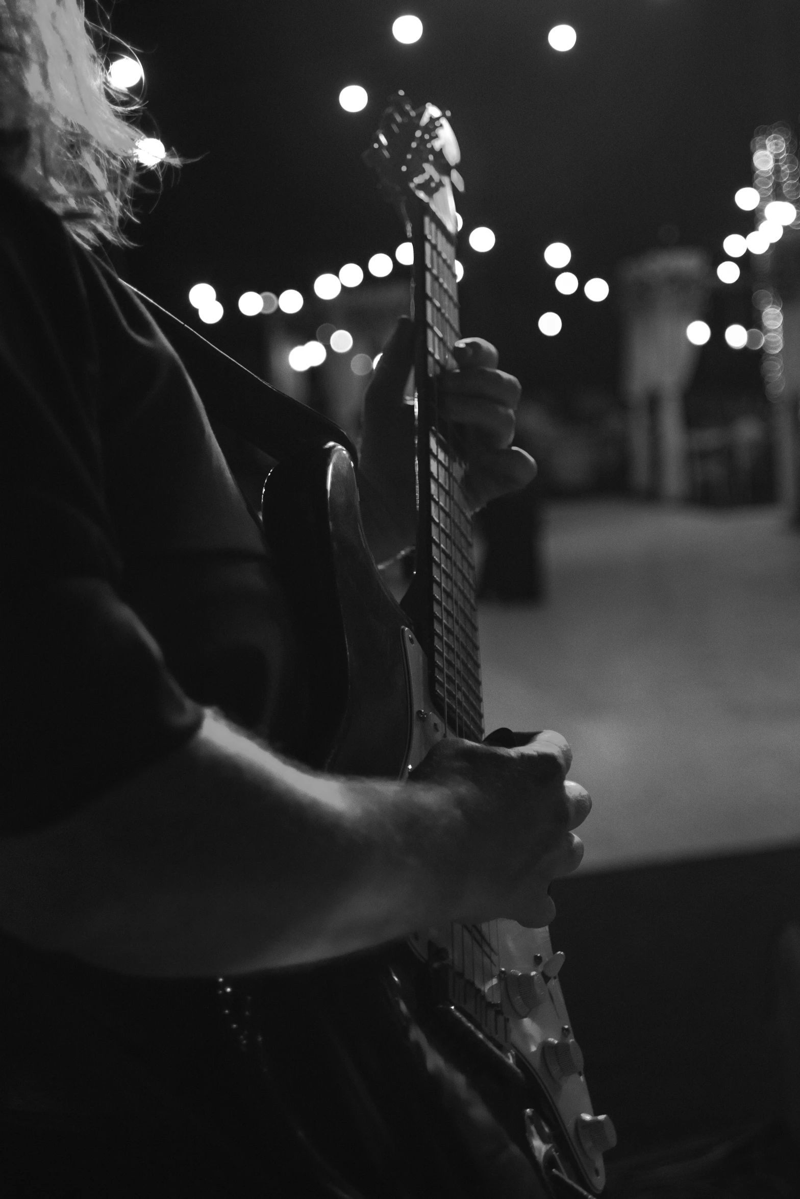 the guitarist is playing a musical instrument under the lights