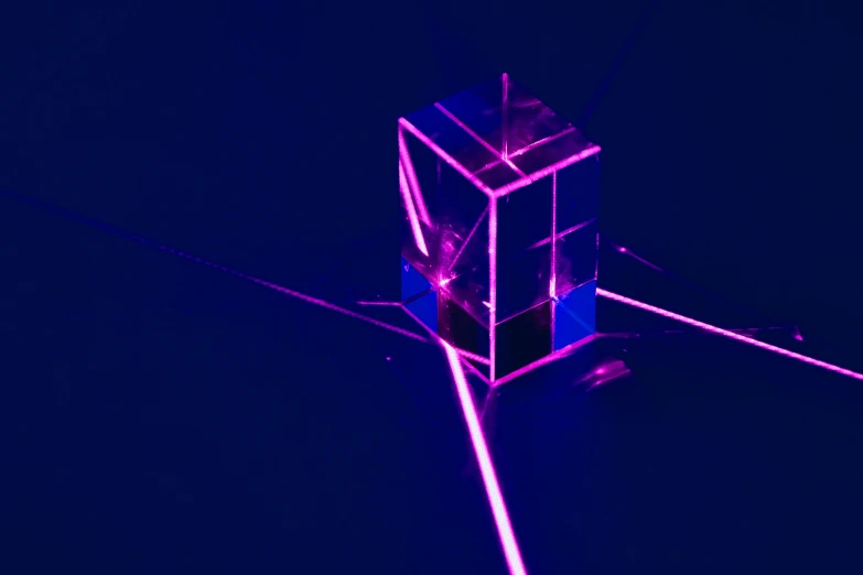 the cube structure is surrounded by glowing pink sticks