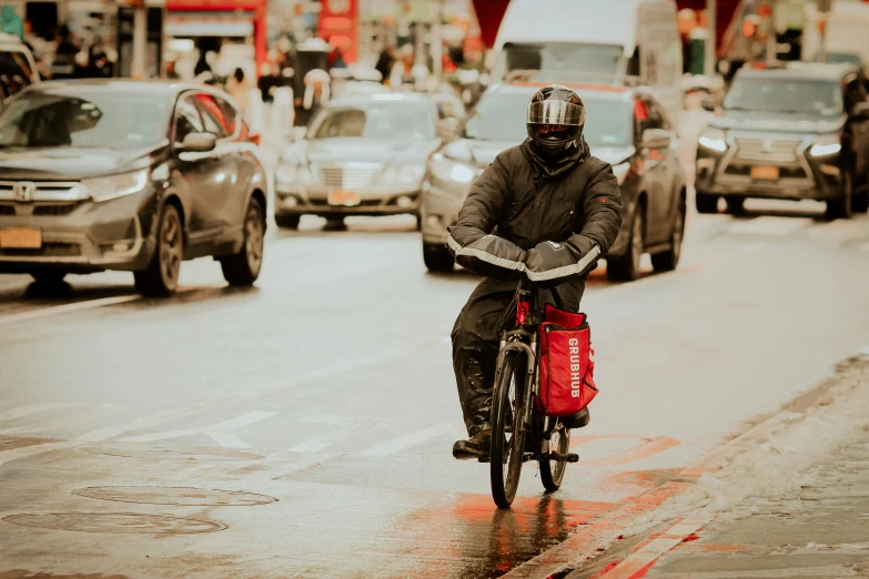 a man on a bicycle in front of some cars