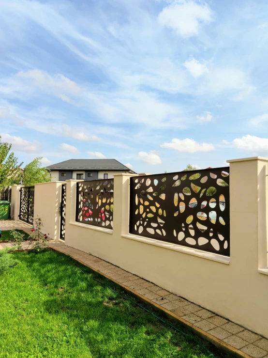 a fence with a decorative pattern and brick walkway