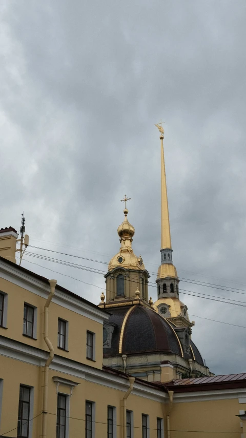 an ornate building with a gold steeple is under grey skies