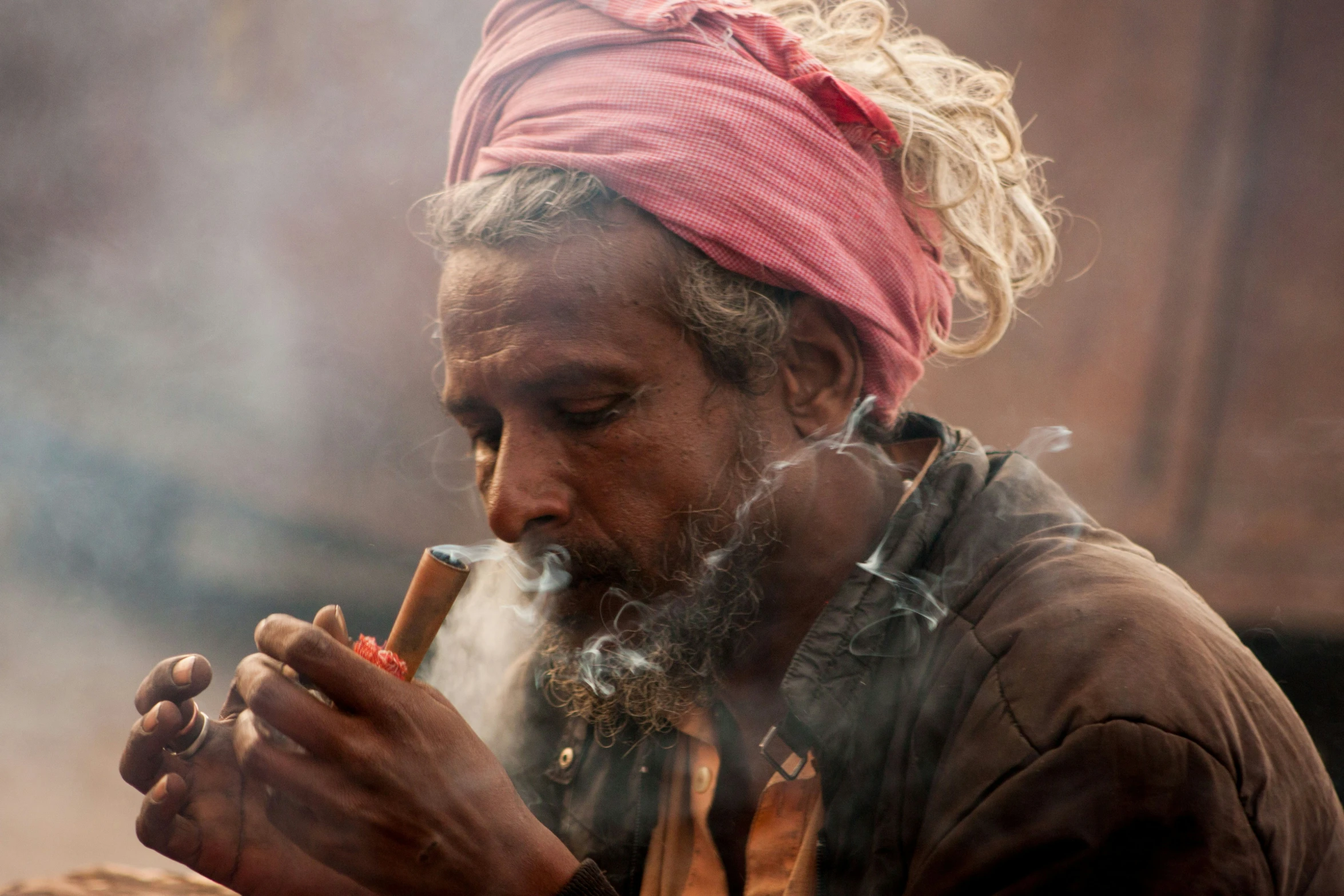 man with bandanna smoking pipe outdoors in the dust