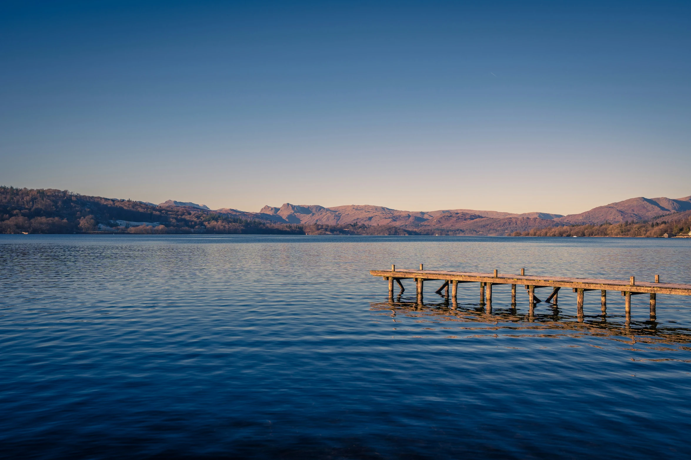 there is a long wooden pier out in the water