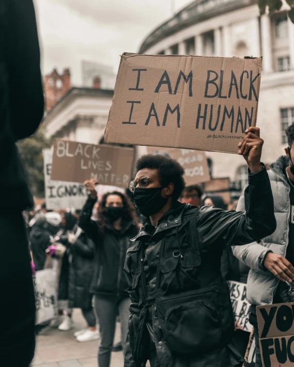 two protesters are holding up protest signs outside a building