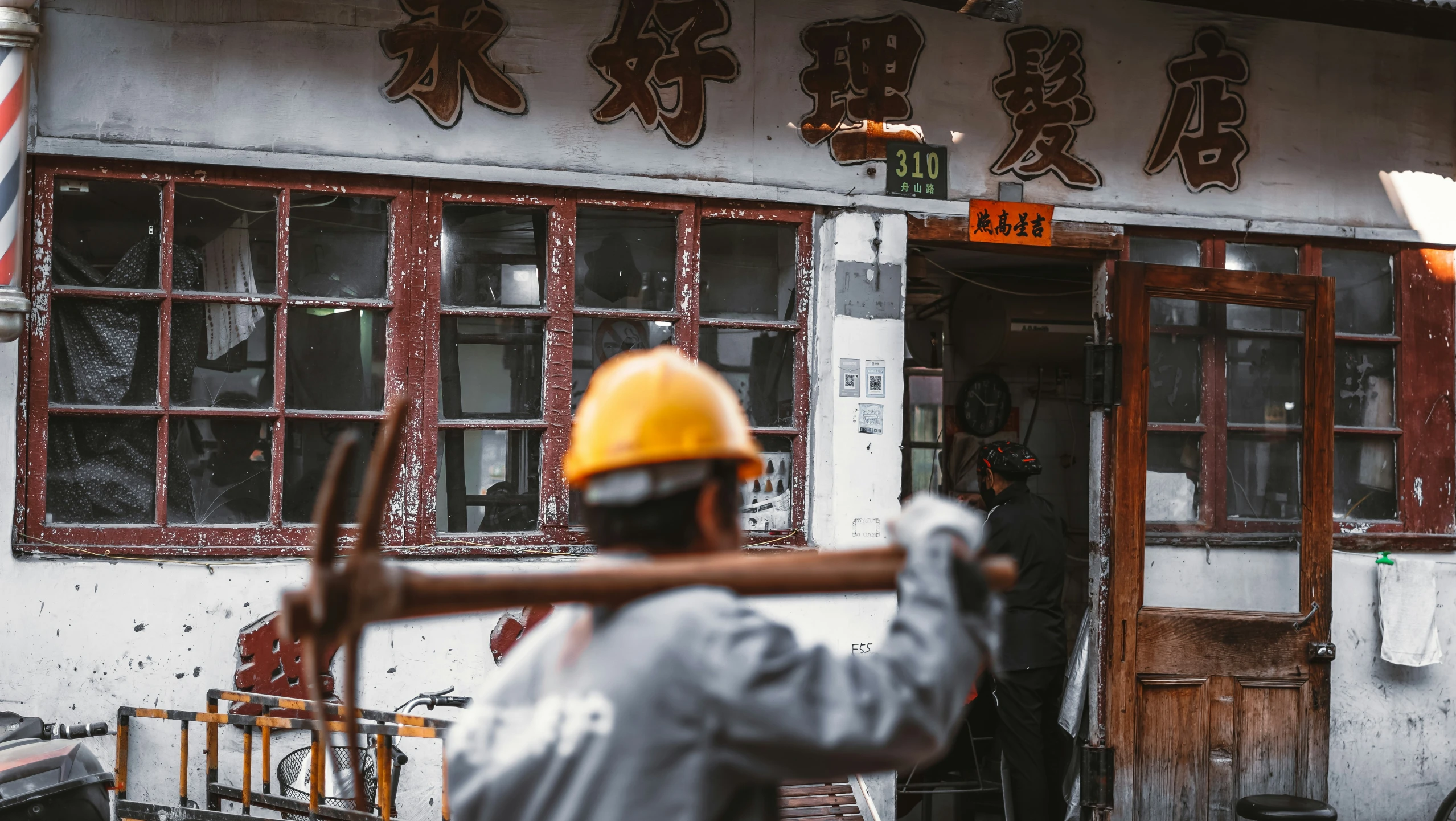 a man with a yellow safety hat stands outside of a building