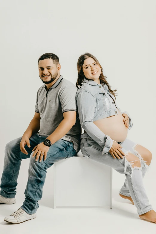 a young pregnant woman and young man sitting next to each other