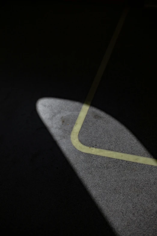 a shadow and part of the floor with a surfboard