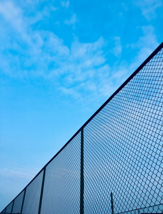 a fence that has a blue sky in the background